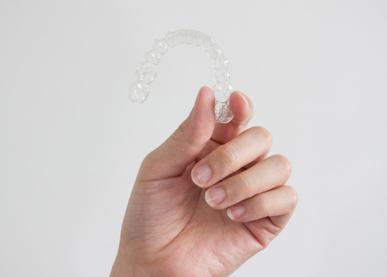 Hand holding a clear aligner