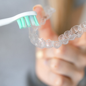 Using toothbrush to clean clear aligner