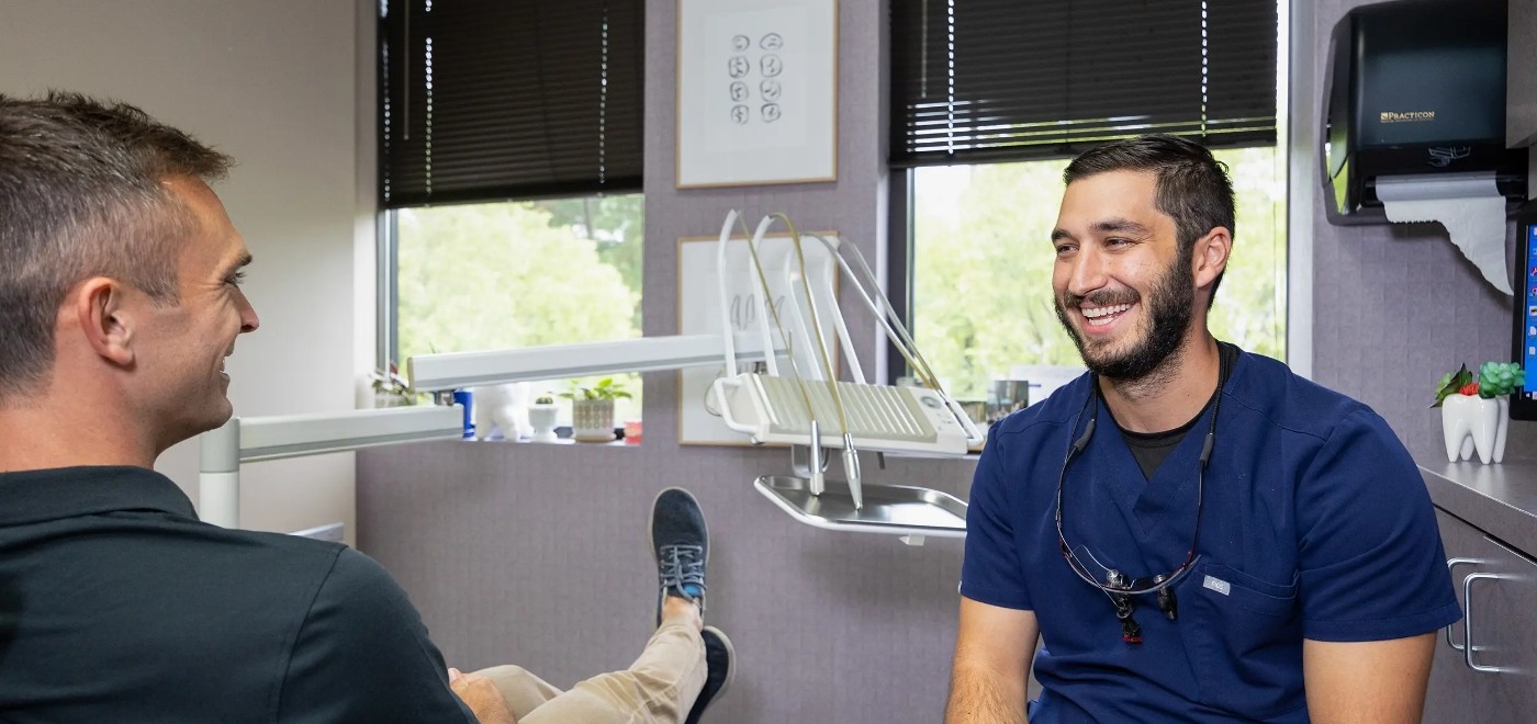 Cosmetic dentist in Garner smiling at a male patient in the dental chair