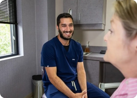 Cosmetic dentist smiling at older female patient