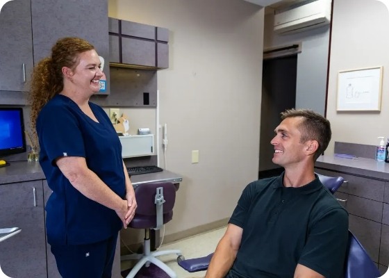 Dental team member smiling at a patient in the dental chair