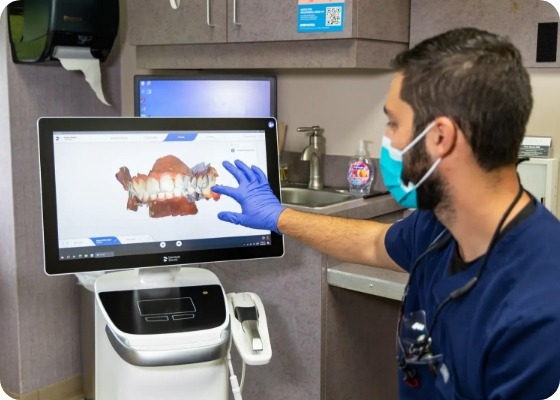 Doctor Samia looking at computer screen with digital scans of teeth